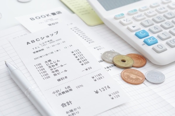 レシートと小銭、電卓（経理代行の費用相場のイメージ）